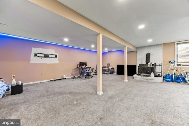 basement with a wood stove, baseboards, carpet flooring, and recessed lighting