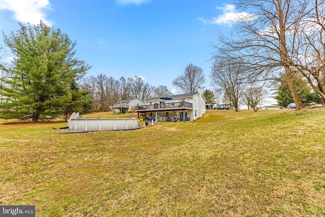 view of yard with a deck and a covered pool