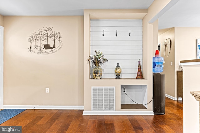 interior space featuring baseboards, visible vents, and hardwood / wood-style floors