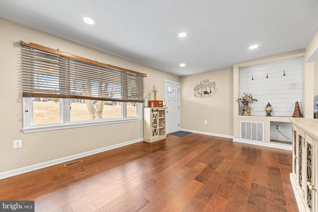 interior space with dark wood-style floors, visible vents, and a healthy amount of sunlight