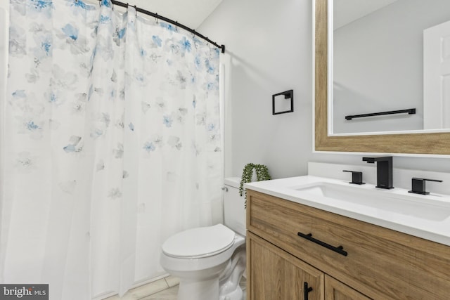 bathroom featuring vanity, tile patterned floors, and toilet