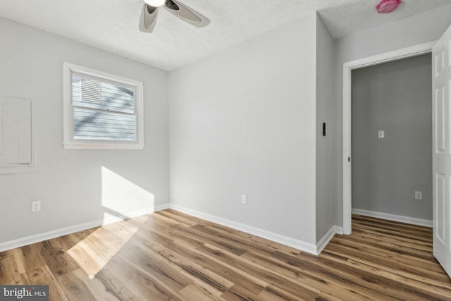 unfurnished bedroom featuring ceiling fan, wood-type flooring, and a textured ceiling