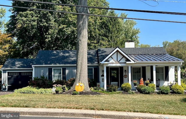 view of front of home with a porch, a garage, and a front yard