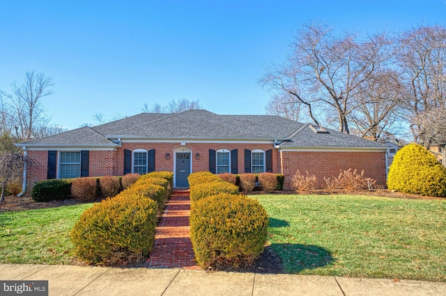 view of front of property with roof with shingles, brick siding, and a front lawn