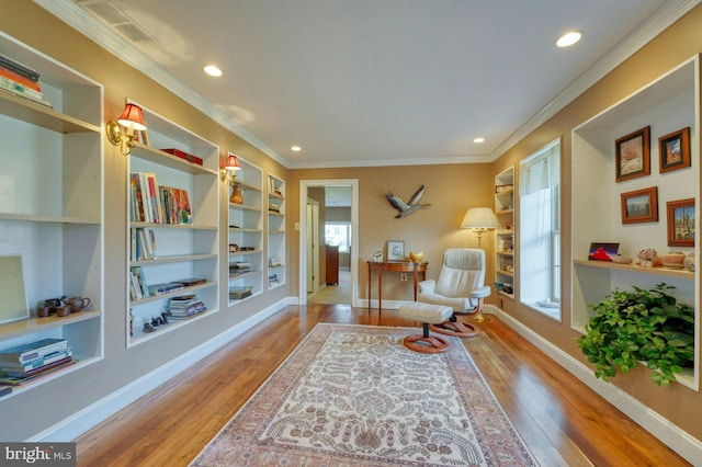 sitting room featuring light wood-style floors, baseboards, and crown molding