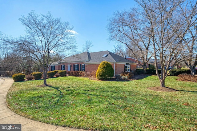 view of side of home with a yard and brick siding