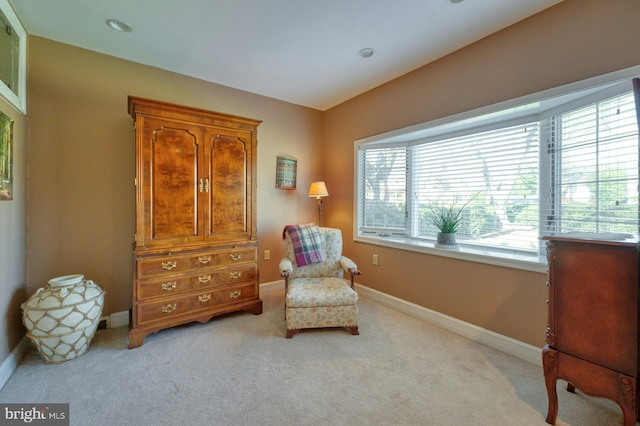 sitting room featuring light carpet and baseboards