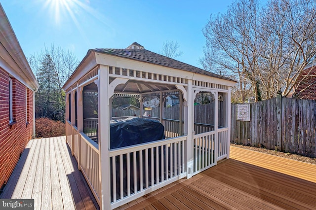 wooden terrace featuring fence and a sunroom