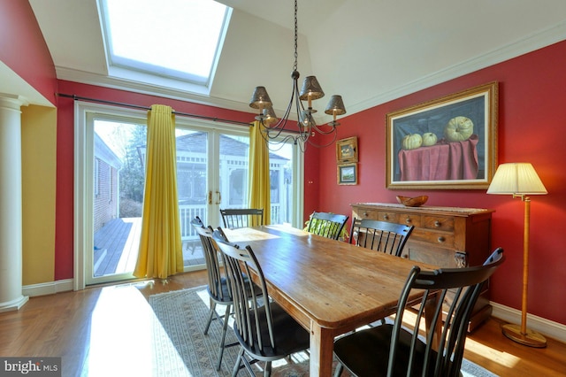 dining area with french doors, decorative columns, light wood finished floors, a chandelier, and baseboards