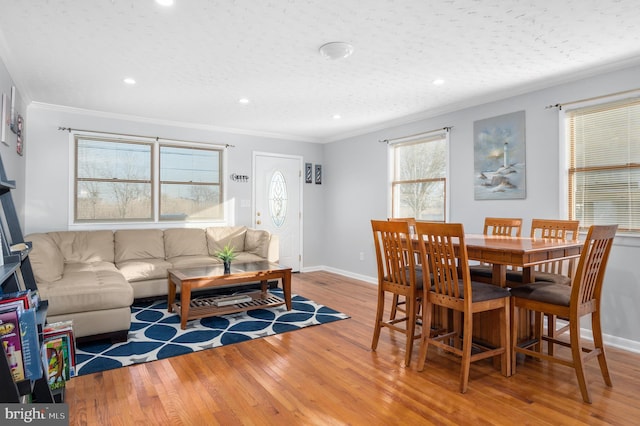 dining area with crown molding and light hardwood / wood-style flooring