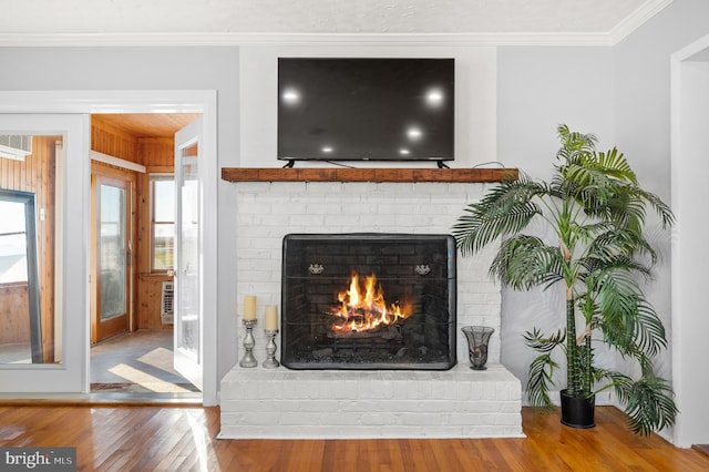 interior details featuring crown molding, hardwood / wood-style flooring, and a fireplace