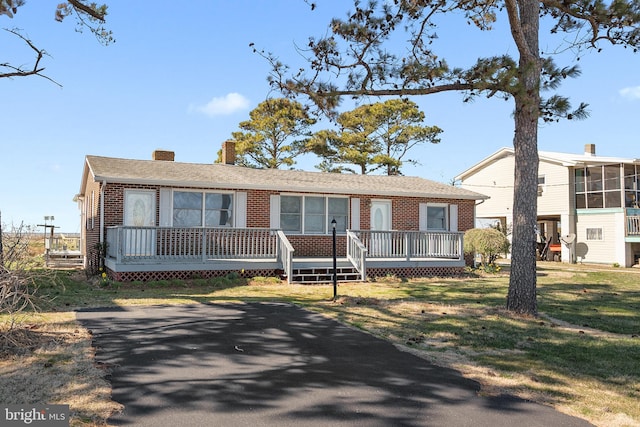 view of front of house with a deck and a front yard