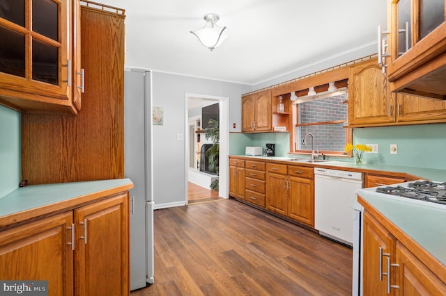 kitchen featuring stainless steel refrigerator, dishwasher, sink, hardwood / wood-style flooring, and crown molding