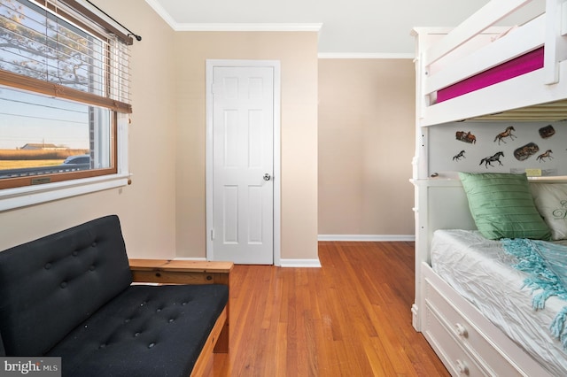 bedroom with ornamental molding and light wood-type flooring