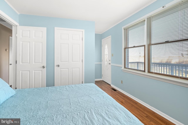 bedroom with crown molding and wood-type flooring