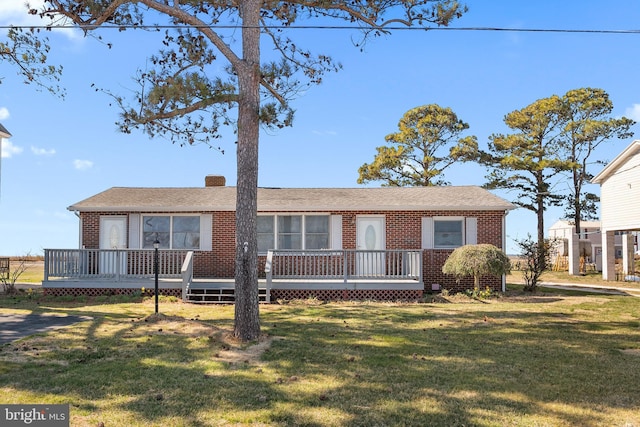 ranch-style house with a deck and a front lawn