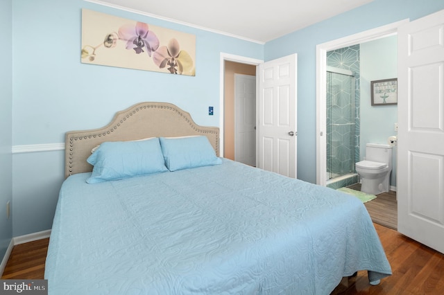 bedroom with wood-type flooring and connected bathroom