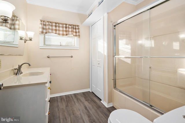 full bathroom featuring crown molding, combined bath / shower with glass door, vanity, wood-type flooring, and toilet