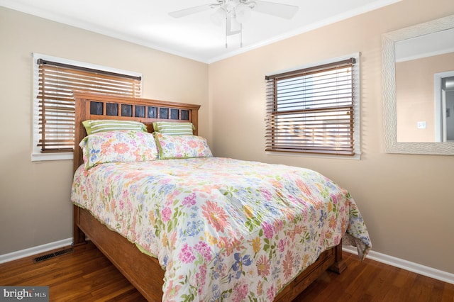 bedroom with crown molding, dark wood-type flooring, and ceiling fan