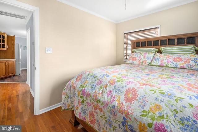 bedroom with hardwood / wood-style flooring and crown molding