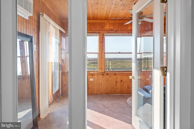 interior space with wooden walls, a wall mounted AC, carpet, wooden ceiling, and french doors