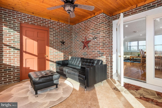 interior space with brick wall, wooden ceiling, and ceiling fan