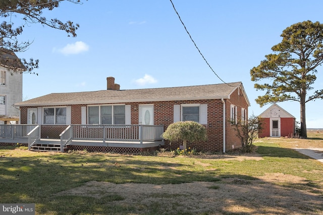 view of front of house with a wooden deck and a front lawn