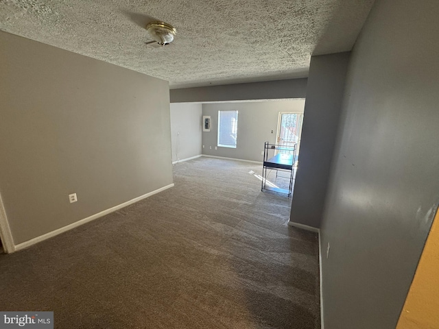 interior space featuring dark carpet and a textured ceiling