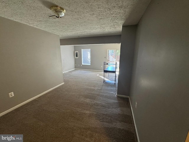 hallway with a textured ceiling and carpet flooring