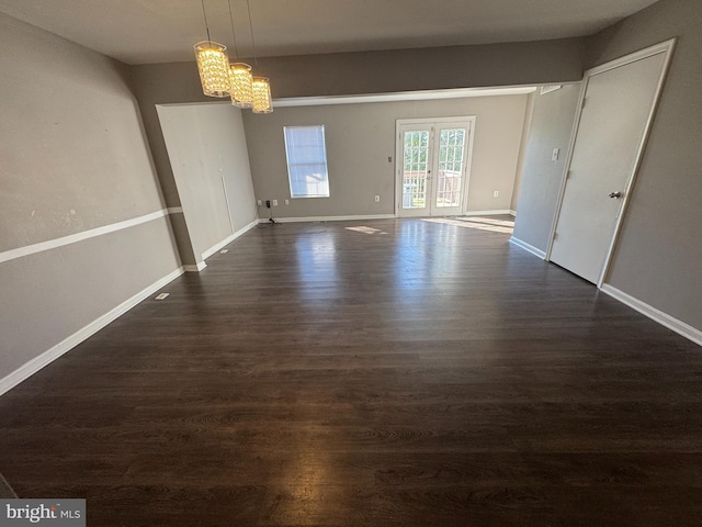 unfurnished dining area with french doors, dark hardwood / wood-style flooring, and a chandelier