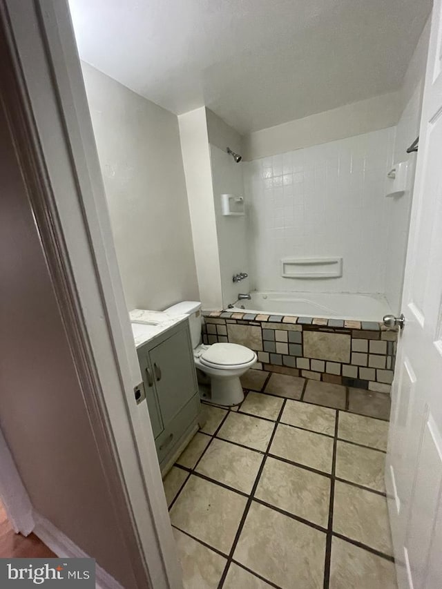 full bathroom with vanity, tile patterned flooring, toilet, and tiled shower / bath