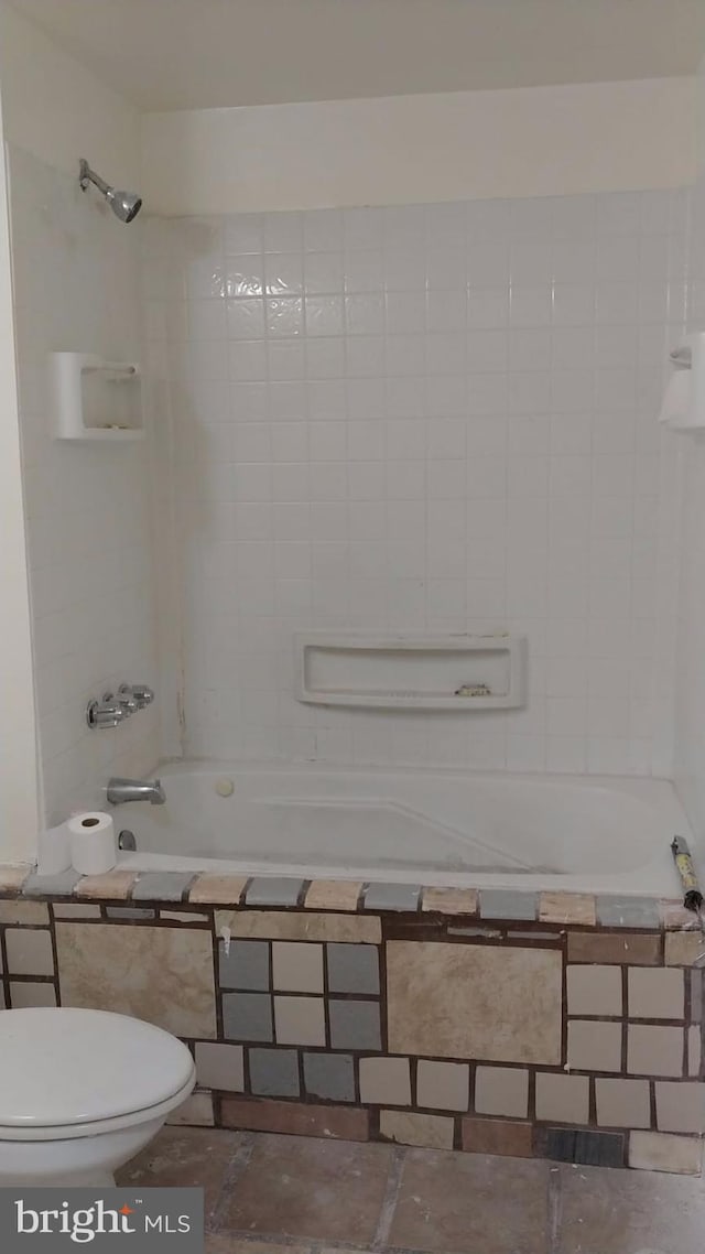 bathroom with toilet and tiled shower / bath combo