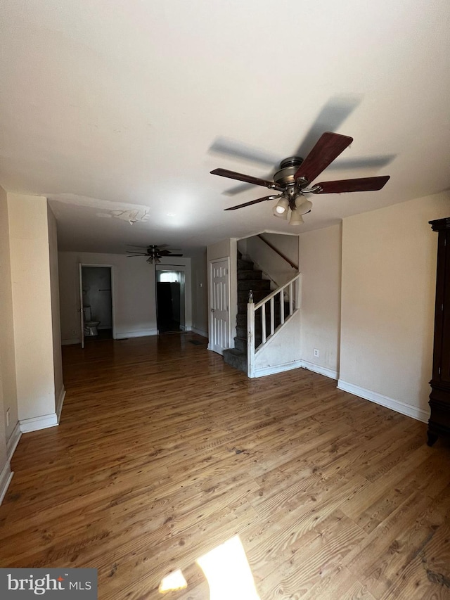 unfurnished living room featuring hardwood / wood-style floors and ceiling fan