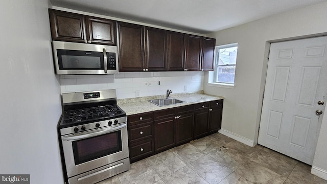 kitchen featuring dark brown cabinetry, sink, backsplash, and stainless steel appliances