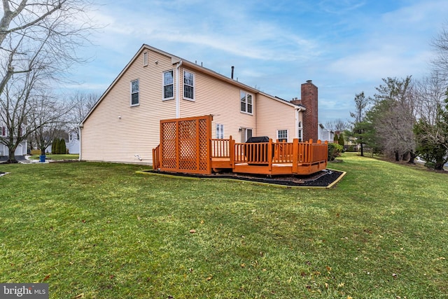 rear view of house with a wooden deck and a yard