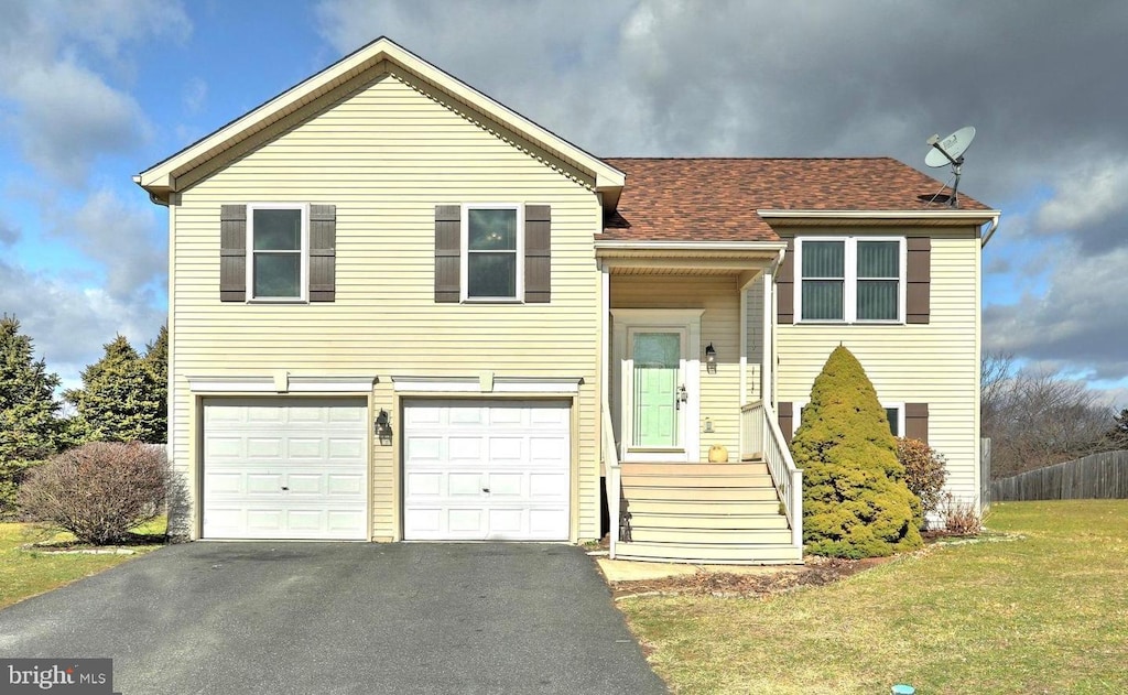 split foyer home featuring a garage and a front lawn