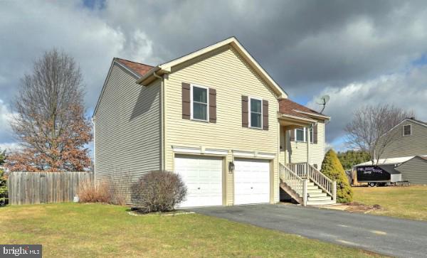 view of side of property with a garage and a lawn