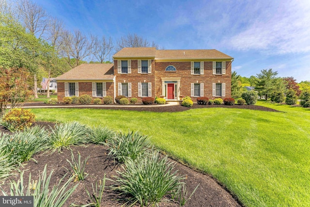 colonial house with brick siding and a front lawn