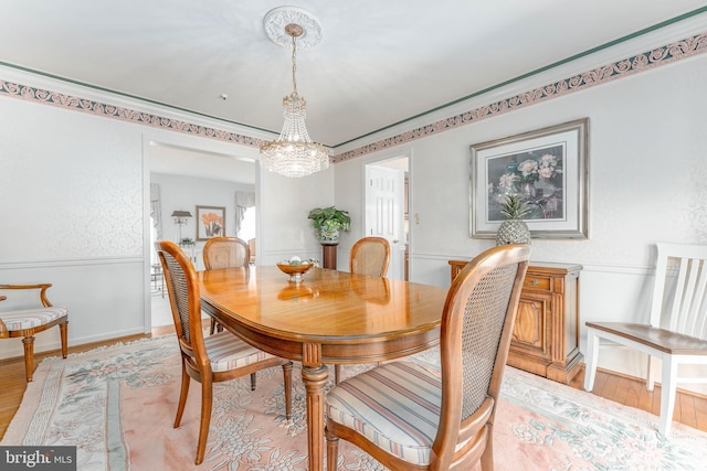 dining area featuring baseboards, light wood finished floors, and a notable chandelier