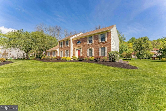 view of front of house featuring brick siding and a front yard