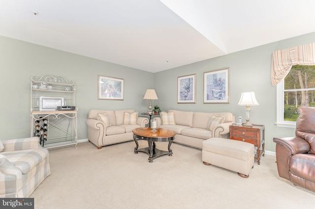 carpeted living area with baseboards