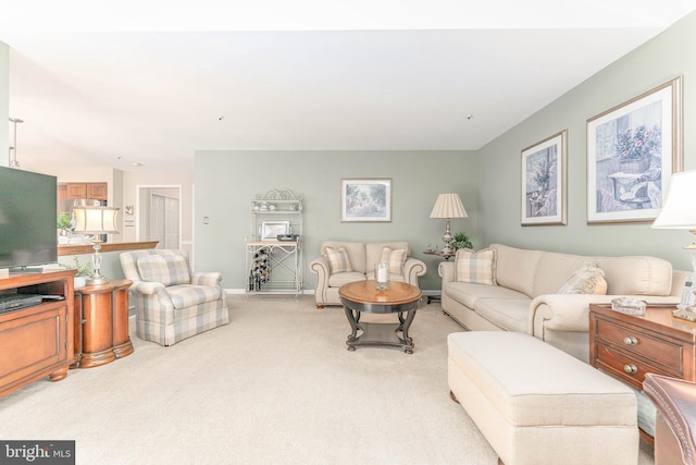 living room featuring baseboards and light colored carpet