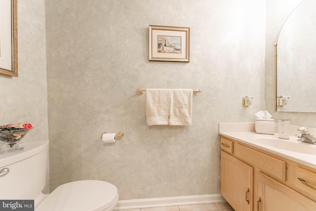 bathroom with vanity, baseboards, tile patterned floors, and toilet