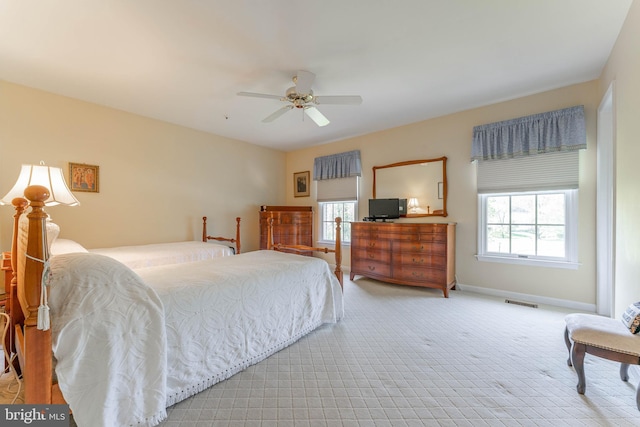 carpeted bedroom with baseboards, ceiling fan, visible vents, and multiple windows