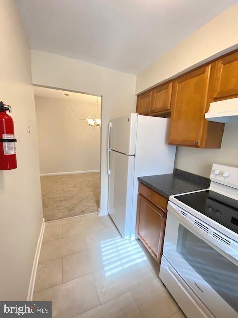 kitchen featuring white appliances and light tile patterned flooring