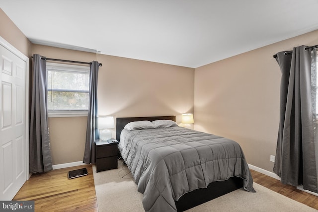 bedroom with baseboards and wood finished floors