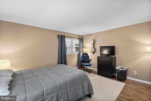 bedroom with wood finished floors and baseboards