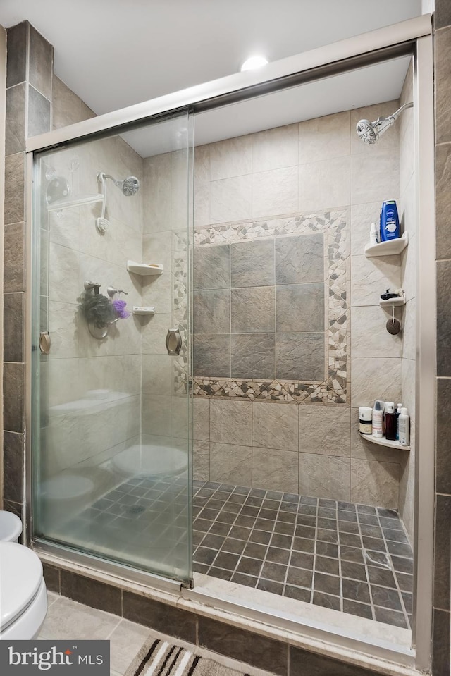 bathroom with a shower stall and toilet