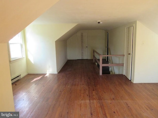 additional living space featuring baseboard heating, vaulted ceiling, and hardwood / wood-style flooring