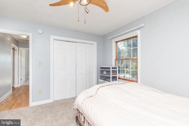 bedroom with light carpet, a closet, a ceiling fan, and baseboards